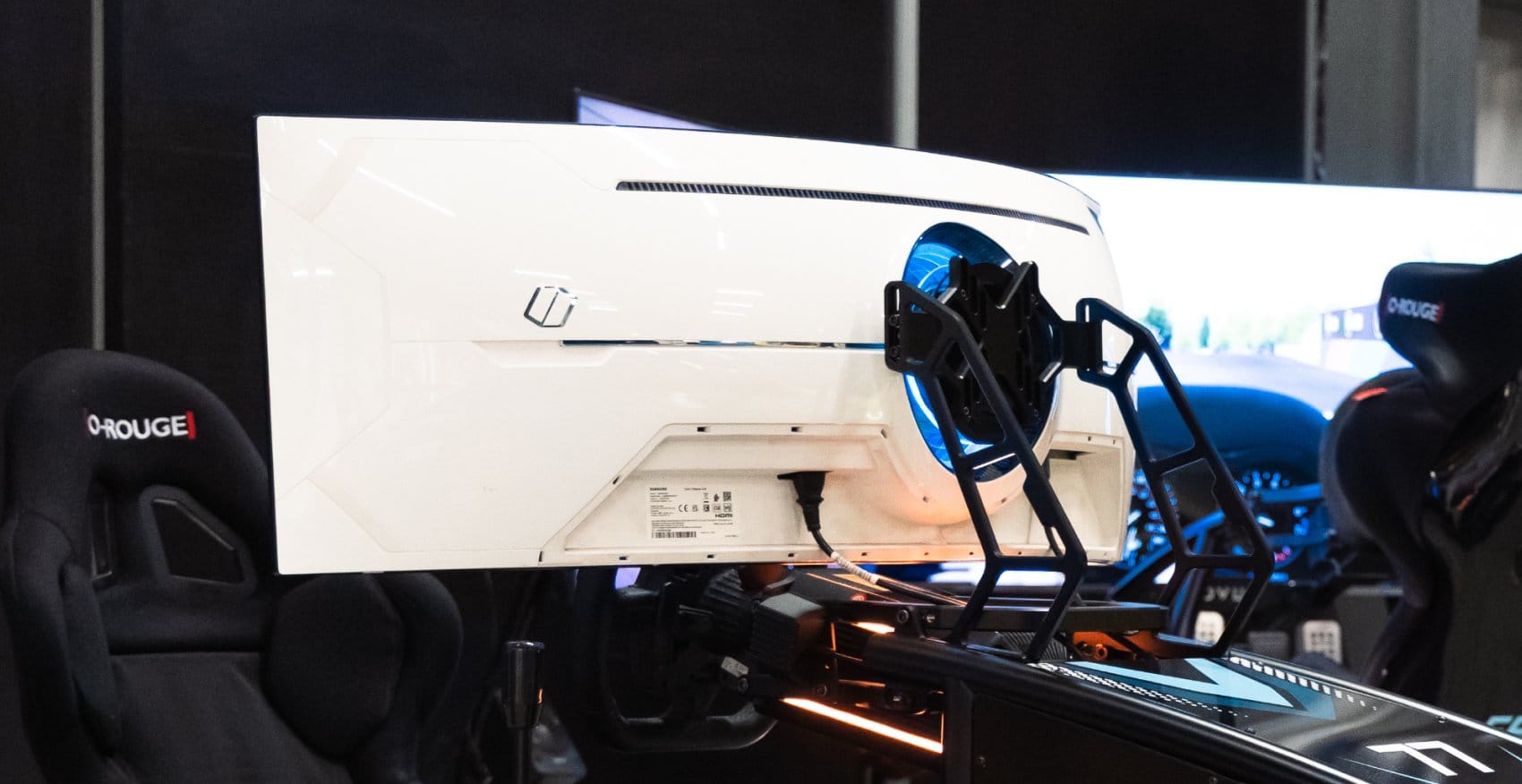 Two racing simulators with triple monitor mounts and bracket systems in professional exhibition setup